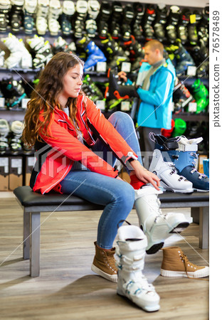 male and female are trying on boots for skiing male and female are trying on boots for skiing 76578489