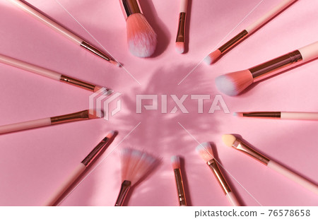 set of makeup brushes on a pink background 76578658