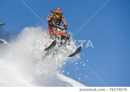Athlete on a snowmobile moving in the mountains Athlete on a snowmobile moving in the mountains 76579079