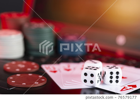 Online gaming platform, casino and gambling business. Cards, dice and multi-colored game pieces on laptop keyboard Online gaming platform, casino and gambling business. Cards, dice and multi-colored game pieces on laptop keyboard 76579177