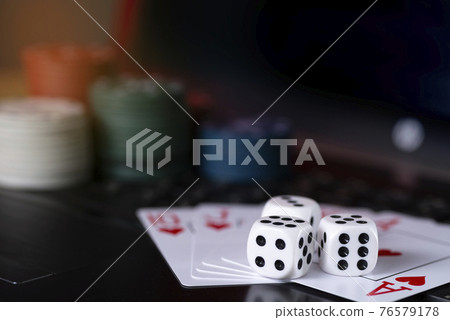 Online gaming platform, casino and gambling business. Cards, dice and multi-colored game pieces on laptop keyboard Online gaming platform, casino and gambling business. Cards, dice and multi-colored game pieces on laptop keyboard 76579178