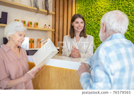 Elderly couple choosing procedures with a specialist in a spa center Elderly couple choosing procedures with a specialist in a spa center 76579565