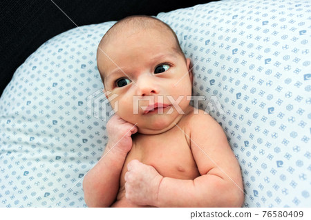 Baby with a very surprised face. Little baby is seriously thinking Baby with a very surprised face. Little baby is seriously thinking 76580409