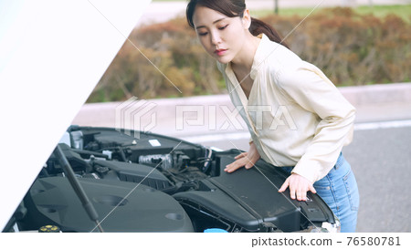 一個打開汽車引擎蓋的女人破壞了道路服務 一個打開汽車引擎蓋的女人破壞了道路服務 76580781