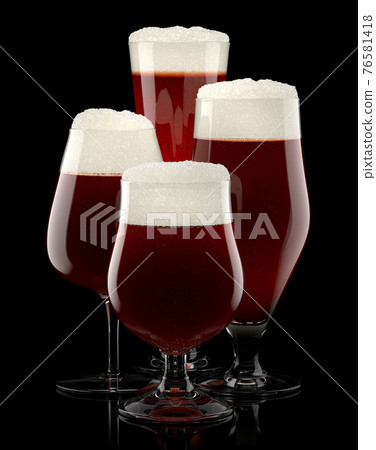 Set of fresh draft beer glasses with bubble froth isolated on black background. 76581418