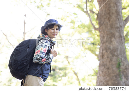 一個女人在新鮮的綠色森林裡享受徒步旅行 一個女人在新鮮的綠色森林裡享受徒步旅行 76582774
