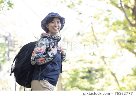 一個女人在新鮮的綠色森林裡享受徒步旅行 76582777