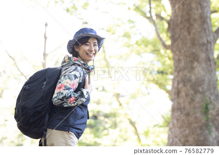 一個女人在新鮮的綠色森林裡享受徒步旅行 一個女人在新鮮的綠色森林裡享受徒步旅行 76582779
