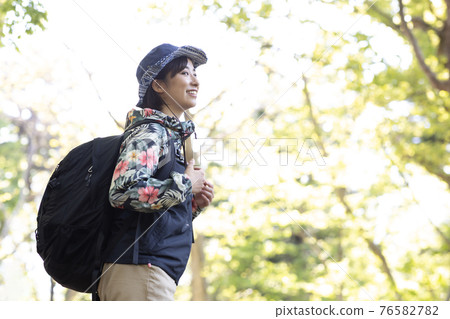 一個女人在新鮮的綠色森林裡享受徒步旅行 76582782