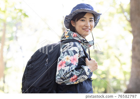 一個女人在新鮮的綠色森林裡享受徒步旅行 一個女人在新鮮的綠色森林裡享受徒步旅行 76582797