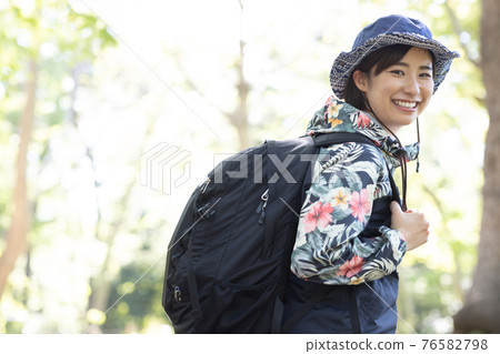 一個女人在新鮮的綠色森林裡享受徒步旅行 一個女人在新鮮的綠色森林裡享受徒步旅行 76582798