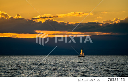 Lonely yacht on Lake Geneva at sunset in Switzerland 76583453