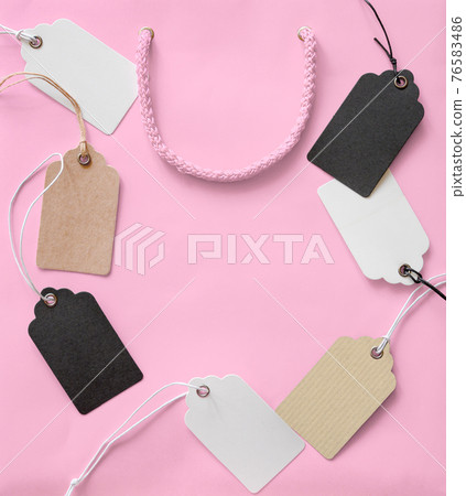 Price tags with rope on pink shopping bag background 76583486