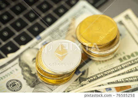 Ethereum coins on a dollars and on a laptop. Trading on the cryptocurrency exchange. Cryptocurrency Stock Market Concept. Mining or blockchain technology. Business concept. Ethereum coins on a dollars and on a laptop. Trading on the cryptocurrency exchange. Cryptocurrency Stock Market Concept. Mining or blockchain technology. Business concept. 76585258