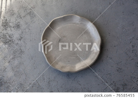 Stone curl gray platter on conrete table Stone curl gray platter on conrete table 76585455