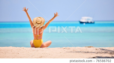 Woman enjoying exotic resort on beach 76586702