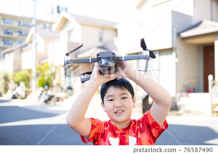 Boy playing with a drone Boy playing with a drone 76587490
