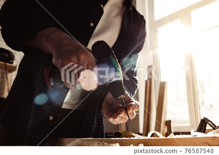 Close up of a carpenter drilling a hole in timber Close up of a carpenter drilling a hole in timber 76587548