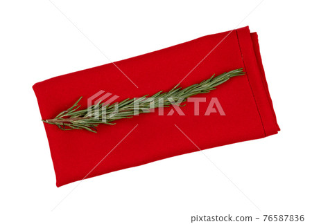 Red paper napkin and rosemary branch on white background Red paper napkin and rosemary branch on white background 76587836