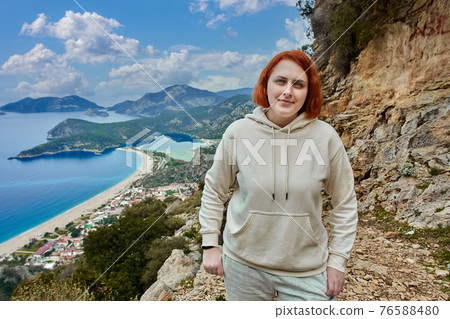 Lycian Trail in Blue Lagoon area of Oludeniz village near Fethiye, young white woman with red hair poses against backdrop of landscape. 76588480