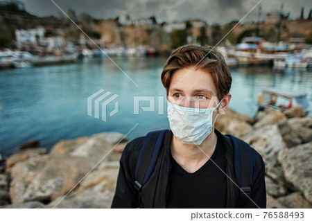 Deserted Turkish resort of Antalya with a lone European tourist wearing protective face mask. Deserted Turkish resort of Antalya with a lone European tourist wearing protective face mask. 76588493