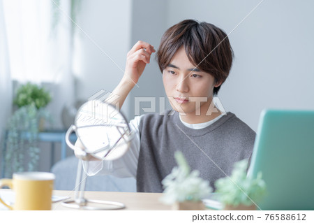 Gen Z who cares about hairstyles in front of the mirror in the living room at home Gen Z who cares about hairstyles in front of the mirror in the living room at home 76588612