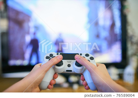 Girl playing video game with joystick at home 76589004