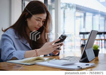Portrait of business woman discussing to his partners about new product while talking with mobile phone in home office. Portrait of business woman discussing to his partners about new product while talking with mobile phone in home office. 76589071