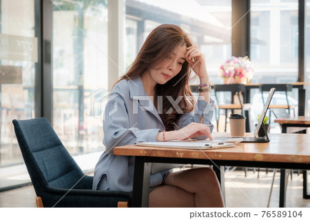 Young asian accountant using calculations. Savings, finances, tax and economy concept. 76589104