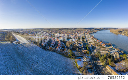 Drone image of wine village Nierstein on the Rhine in blue sky and sunshine with snow covered slopes Drone image of wine village Nierstein on the Rhine in blue sky and sunshine with snow covered slopes 76589352