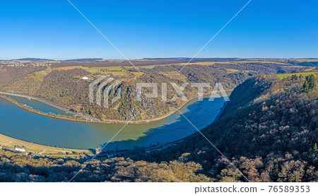 Panoramic drone image of the Loreley rock on the Rhine river taken from the opposite side of the Rhine under blue sky and sunshine 76589353