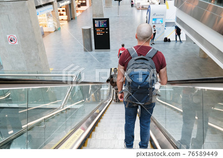 St. Petersburg, Russia, Alexander Kirillov - 26082019: Pulkovo Airport, a man goes down the escalator 76589449