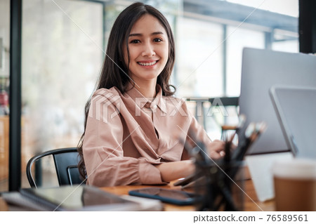Young Pretty business woman smiling and sitting at home office. work from home concept. Young Pretty business woman smiling and sitting at home office. work from home concept. 76589561