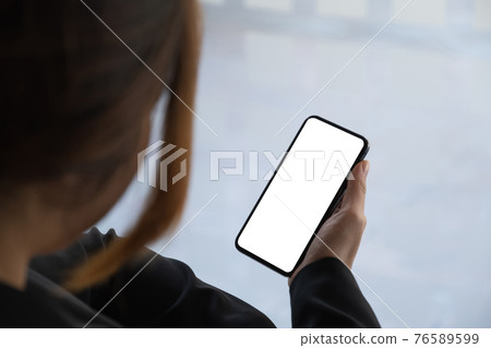 Woman using smartphone blank screen frameless modern design while work from home Woman using smartphone blank screen frameless modern design while work from home 76589599