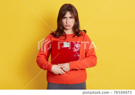 Displeased Caucasian woman holding weight-scales in hands and looking directly at camera with sad expression, being afraid to get fat, need diet, looks upset, expresses sadness. Displeased Caucasian woman holding weight-scales in hands and looking directly at camera with sad expression, being afraid to get fat, need diet, looks upset, expresses sadness. 76589973