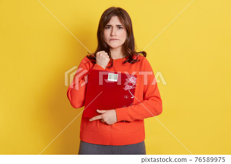 Young attractive model holding scales in hands, being upset, keeping fist near face and bites lip, need to loose weight, does not know how to slim down. Young attractive model holding scales in hands, being upset, keeping fist near face and bites lip, need to loose weight, does not know how to slim down. 76589975