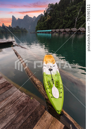 Beautiful morning view with kayak in sunrise sky and natural attractions in Ratchaprapha Dam at Khao Sok National Park Beautiful morning view with kayak in sunrise sky and natural attractions in Ratchaprapha Dam at Khao Sok National Park 76590311