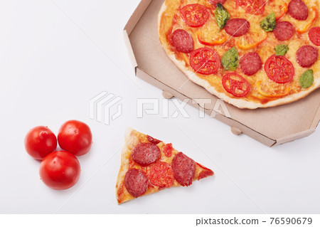 Photo of pepperoni pizza with mozzarella cheese, salami, pepper, spices and fresh spinach, cardboard box, piece of pizza and three tomatoes isolated on white background. Fast food eating concept. Photo of pepperoni pizza with mozzarella cheese, salami, pepper, spices and fresh spinach, cardboard box, piece of pizza and three tomatoes isolated on white background. Fast food eating concept. 76590679