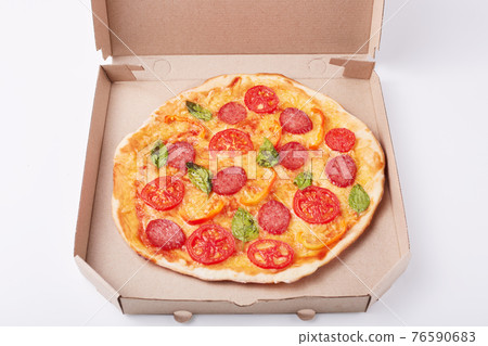 Image of fresh tasty pizza in cardboard box on white surface, picture of fast food dish, supper from restaurant or cafe. Fast food eating concept. Open box with delicious pepperoni pizza on table. 76590683