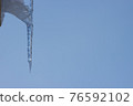 Icicle icy against the blue sky. 76592102