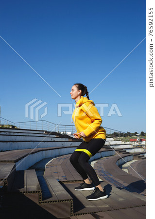 young woman doing sports outdoors by the sea young woman doing sports outdoors by the sea 76592155