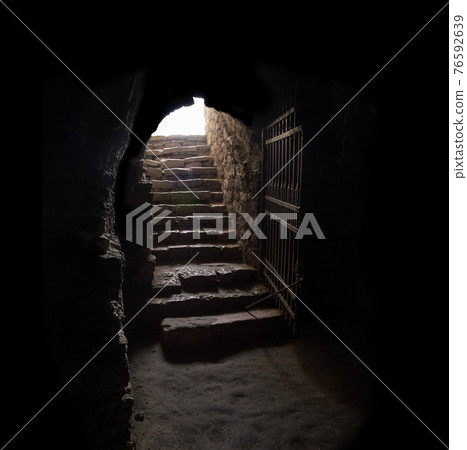 Stone hallway with upward staircase 76592639