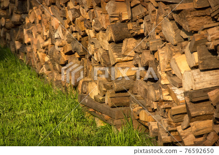 Old firewood on green grass Old firewood on green grass 76592650