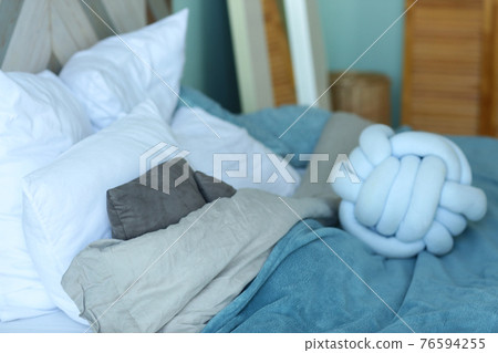 cute modern bedroom corner blue bad, pillows, duvet closeup photo 76594255