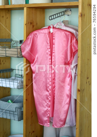 bedroom corner with open wardrobe and pink robe hanging closeup photo 76594294