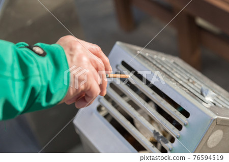 Hands of a man smoking a cigarette 76594519