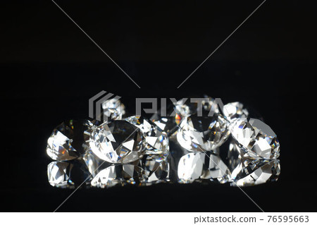 Several excellent pure diamonds with reflection on black mirror background close up view selective focus. Jewelry diamonds sale, invitation, action, discount banner, poster, card template copy space 76595663