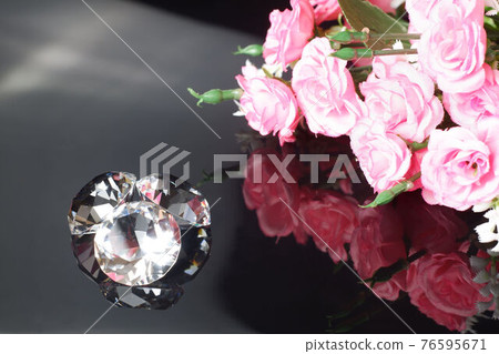 Three excellent diamonds of the first water and bouquet of pink roses with reflection on black mirror background close up view. Jewelry diamonds sale, invitation, action, discount banner, poster Three excellent diamonds of the first water and bouquet of pink roses with reflection on black mirror background close up view. Jewelry diamonds sale, invitation, action, discount banner, poster 76595671