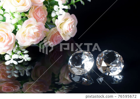 Couple of wonderful pure diamonds and bouquet of tea roses with reflection on black mirror background close up view. Jewelry diamonds sale, invitation, action, discount banner, poster template Couple of wonderful pure diamonds and bouquet of tea roses with reflection on black mirror background close up view. Jewelry diamonds sale, invitation, action, discount banner, poster template 76595672