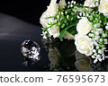 Excellent diamond of the first water and bouquet of white roses with reflection on black mirror background close up view. Jewelry diamonds sale, invitation, action, discount banner, poster template 76595673